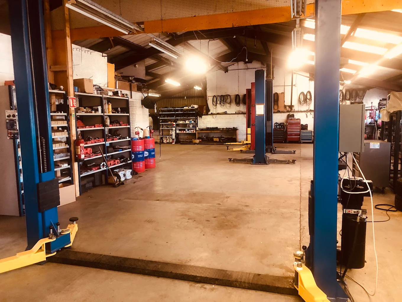 Fast Fit Kilkenny workshop interior with two-post car lifts and parts shelving